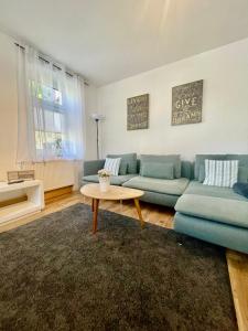 a living room with a blue couch and a table at Apartment Steinbruch in Bad Schandau