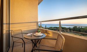 a balcony with a table and chairs and a view of the ocean at Aminess Vival Maestral Hotel in Novigrad Istria