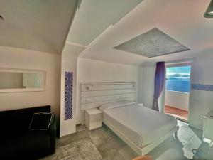 een witte slaapkamer met een bed en een raam bij Villa Bossa in Amalfi