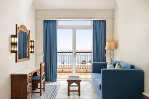 sala de estar con sofá azul y ventana grande en Movenpick Resort Sharm El Sheikh, en Sharm El Sheikh