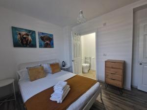 een slaapkamer met een bed met handdoeken erop bij LOLO PROPERTIES 2, Free Parking in Edinburgh