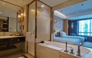a bathroom with a tub and a large mirror at InterContinental Shijiazhuang, an IHG Hotel in Shijiazhuang