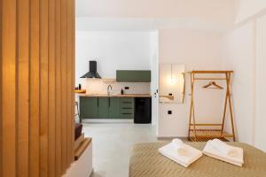 a small kitchen with green cabinets and a table at ASTRA in Parga