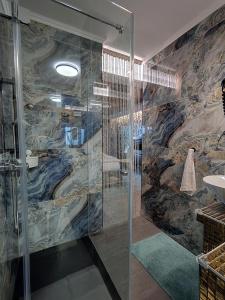łazienka z prysznicem i kamienną ścianą w obiekcie Romantisches Bergapartment - Luxus Studio auf der Simonhöhe w mieście Zirkitz