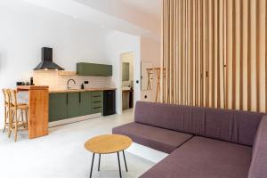 a living room with a purple couch and a kitchen at ASTRA in Parga