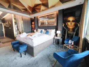 sypialnia z dużym łóżkiem i 2 niebieskimi krzesłami w obiekcie Romantisches Bergapartment - Luxus Studio auf der Simonhöhe w mieście Zirkitz
