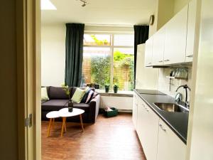 a kitchen and living room with a couch and a table at Huisje De Deining in Ermelo