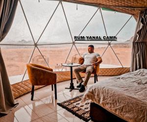 a man sitting at a table in a room with a view at RUM YANAL CAMP in Wadi Rum