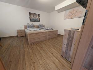 a room with a bed and wooden floors at Souterrainwohnung in Gottmadingen