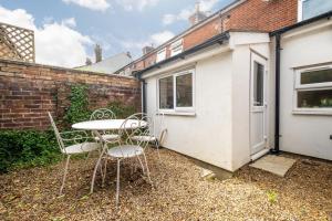 een terras met een tafel en stoelen voor een gebouw bij Charming Kings road in Bury Saint Edmunds