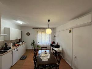 a kitchen and dining room with a table and chairs at Apartman Velojić in Donji Milanovac
