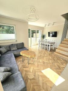 una sala de estar con un sofá y una mesa en M&K Apartamenty Przystań Świbno, en Gdansk