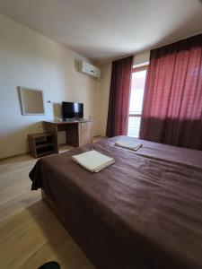 a bedroom with a bed with two towels on it at Акра-Ф in Chernomorets