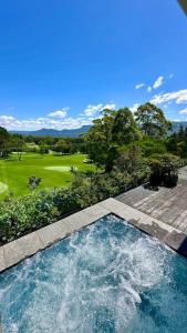 a swimming pool with a view of a golf course at Ralphie’s Villa 2 bed 2 bath with Valley views in Kangaroo Valley