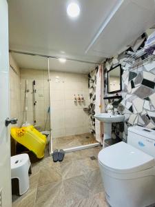 a bathroom with a shower and a toilet and a sink at 家暖暖,老屋新生,房源內有戶外空間,嘉義市民宿013號 in Chiayi City