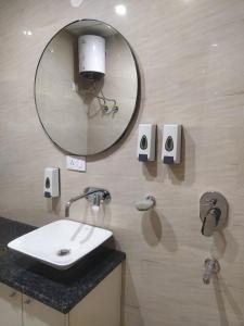 グルガオンにあるLimewood Stay - Near Golf Course Roadの洗面台と壁に鏡が付いたバスルーム