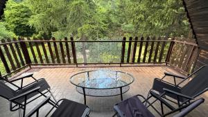 d'une terrasse avec une table, des chaises et une clôture. dans l'établissement Lodge Zbilje Visoko, Bosnian Pyramids, à Visoko