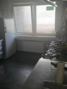 cocina con fogones y 2 ventanas. en Feierabend Elsdorf, en Elsdorf