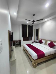 a bedroom with a large bed with red pillows at Hotel NEU-NEST in Rishīkesh