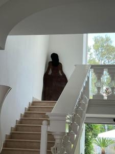 a woman sitting on the stairs of a house at Relais Corte Degli Aragonesi in Ischia