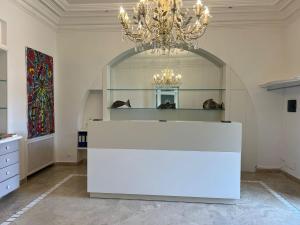 a large room with a chandelier and a white counter at Relais Corte Degli Aragonesi in Ischia