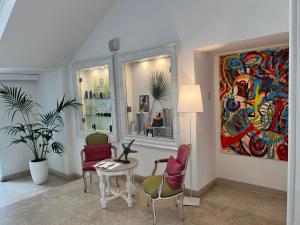 a living room with a table and chairs and a painting at Relais Corte Degli Aragonesi in Ischia