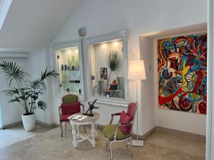 a living room with a table and chairs and a painting at Relais Corte Degli Aragonesi in Ischia