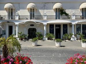 a white building with flowers in front of it at Relais Corte Degli Aragonesi in Ischia
