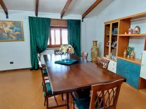 a dining room with a wooden table and chairs at Emerald of Sanluri in Sanluri