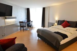 Un dormitorio con una cama grande y una mesa con sillas. en Hotel Egerkingen, idealer Zwischenstopp, en Egerkingen