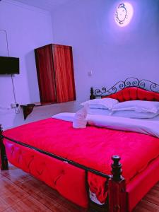 1 dormitorio con cama roja y manta roja en Js Hotel & Accommodation, en Nakuru