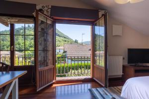 sypialnia z drzwiami wychodzącymi na balkon w obiekcie Urdaibai Boutique w mieście Altamira