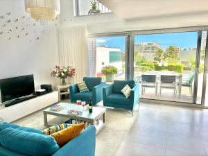 un soggiorno con divani blu e TV di Luxury villa & private heatable pool in Albufeira ad Albufeira