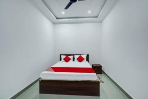 迪布魯加爾的住宿－Super OYO Flagship The Mahalaxmi Inn，白色客房,配有红色床单