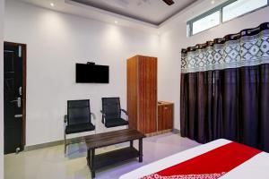 ein Schlafzimmer mit einem Bett und einem TV an der Wand in der Unterkunft Super OYO Flagship The Mahalaxmi Inn in Dibrugarh