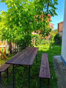 uma mesa de piquenique de madeira e dois bancos num quintal em La Piccola Casa di Via Ricotti em Castelguglielmo