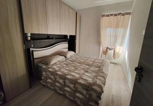 um quarto com uma cama e uma janela em Il Sole dell' Altopiano em Villa Opicina