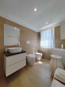 uma casa de banho com 2 lavatórios, uma banheira e um WC. em La Piccola Casa di Via Ricotti em Castelguglielmo