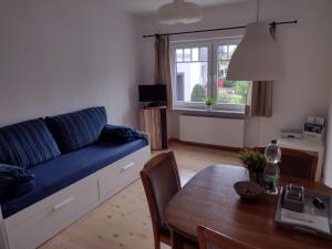 a living room with a blue couch and a table at Ferienwohnung mit Herz in Nauort