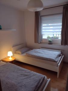 1 dormitorio con 2 camas y ventana en Ferienwohnung mit Herz, en Nauort