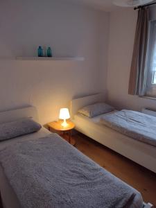 ein Schlafzimmer mit 2 Betten und einer Lampe auf einem Tisch in der Unterkunft Ferienwohnung mit Herz in Nauort