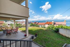 a balcony of a house with a table and chairs at Apartmani Krtica 1 in Vrbnik