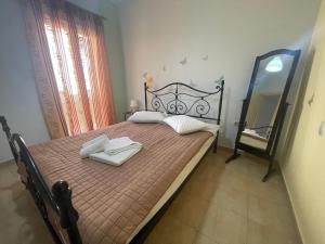 a bedroom with a bed with two towels on it at 90sqm Perdika Aegina luxury family apartment με θέα βουνό και θάλασσα 90τμ in Perdhika