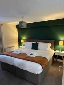 1 dormitorio con 1 cama grande y cabecero verde en Orange Lilly In Stroud With Free Parking en Stroud