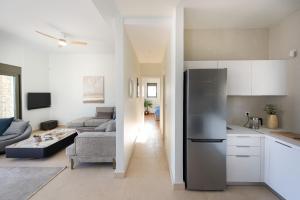 eine Küche und ein Wohnzimmer mit einem Kühlschrank in der Unterkunft Seascape Kalyves in Kalyves