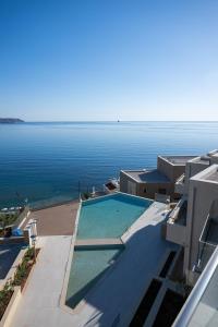 ein Swimmingpool auf einem Gebäude neben dem Wasser in der Unterkunft Seascape Kalyves in Kalyves