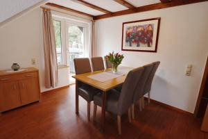 uma mesa de jantar com cadeiras e um vaso de flores em Haus Sonnentau em Monschau