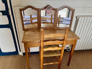 a wooden table with a mirror and a chair at La Villa Ker Mat in Larmor-Plage