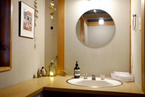 a bathroom with a sink and a mirror at 'Imi Ola House in Yufuin
