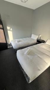 2 camas en una habitación de hotel con sábanas blancas en Twelve - Boutique Guest House -Galway City Centre -6 Bed En-Suite - Free Parking, en Galway